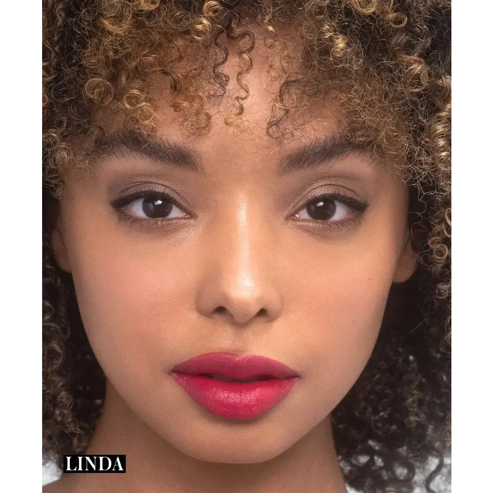 Close-up of a person with curly hair and red lipstick. Text: "Linda" in the corner.