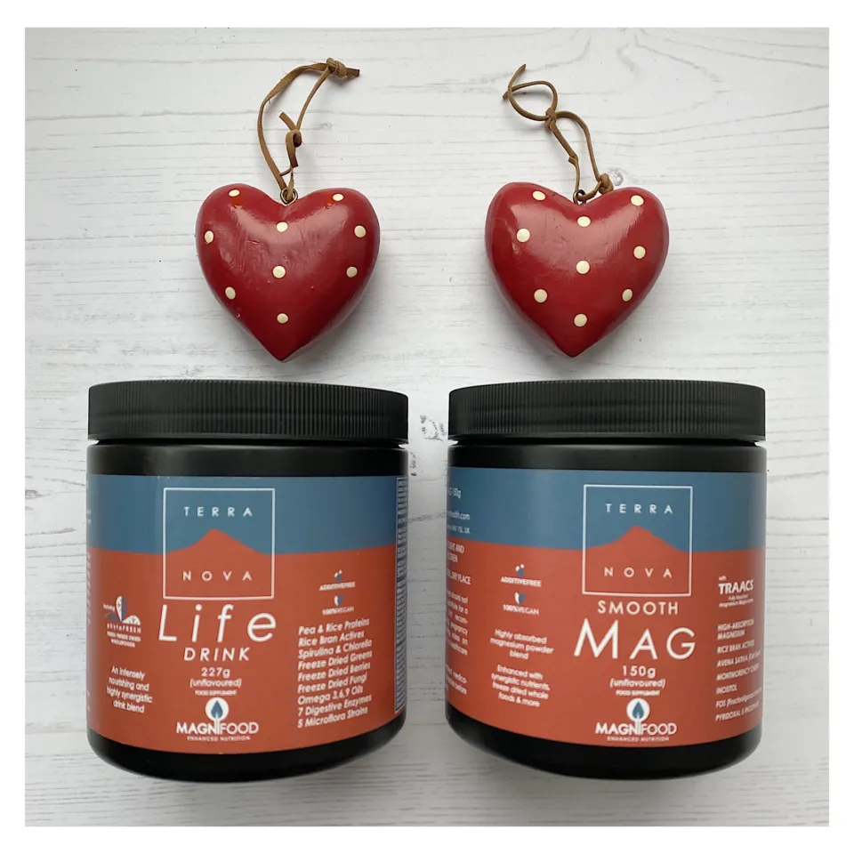 Two jars of Terra Nova supplements with red heart decorations above.