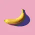 Yellow banana with shadow on a pink background.