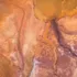 Aerial view of orange and brown mineral patterns resembling a desert landscape.