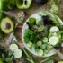 Salad with cucumber, avocado, broccoli, and greens on a wooden table.