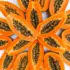 Halved papayas with black seeds arranged in a circular pattern on a white background.