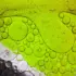 Green and grey oil bubbles in water, forming abstract patterns.