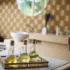 Glass bottles of oil on a wooden tray in a spa room with patterned walls.