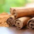 Cinnamon sticks and ground cinnamon on a wooden surface.