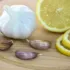 Garlic bulb, cloves, and lemon slices on a wooden board.