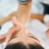 Person receiving a facial treatment with a compact mirror nearby.