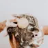 Person washing hair with a round shampoo bar, lathered with foam.