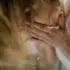 Person washing face with water, hands cupped, hair falling forward.