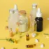 Assorted skincare bottles and capsules on a yellow background.