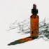 Amber dropper bottle casting a shadow on a white surface.