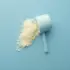 Blue scoop with white powder on a blue background.
