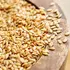 Sesame seeds spilling from a wooden bowl.