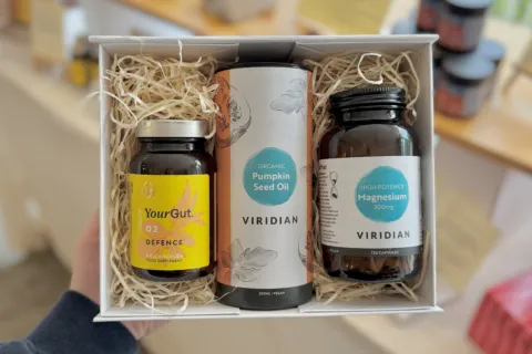 Gift box with YourGut Defence, Pumpkin Seed Oil, and Magnesium supplements on display.