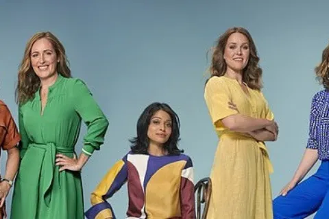 Five women in colourful outfits against a blue background.