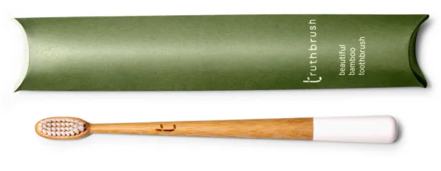 Bamboo toothbrush with white handle and green packaging labelled "truthbrush".