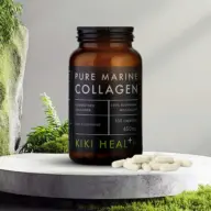 Brown bottle of Pure Marine Collagen capsules on a stone surface with greenery.