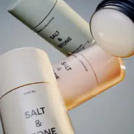 Four Salt & Stone deodorant sticks in various colours, angled against a grey background.
