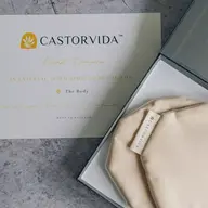 Castorvida breast compress with label in box, card with instructions on stone surface.
