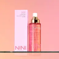 NINI Organics Rosé Hydrating Mist with pink box on glass shelf.