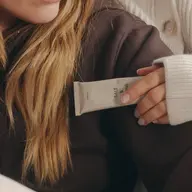 Person holding a tube labelled "Salt & Vine" against a brown jumper.