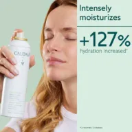 Woman using Caudalie Grape Water spray. Text: "Intensely moisturises, +127% hydration increased".