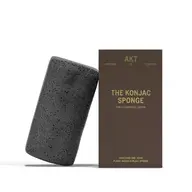 Black konjac sponge next to brown box labelled "The Konjac Sponge".