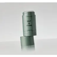 Salt & Stone deodorant gel in a green container, open with cap on the side.