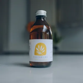 Brown bottle with Castorvida label on a white surface.