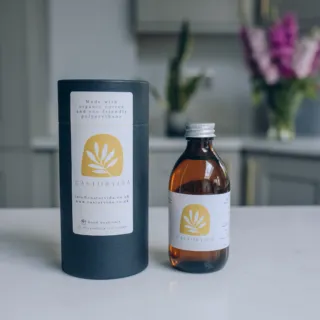 Castorvida bottle and packaging on a kitchen counter with flowers in the background.
