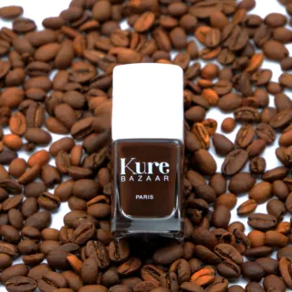 Kure Bazaar nail polish bottle on coffee beans.
