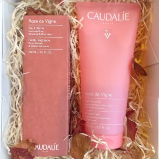 Caudalie Rose de Vigne shower gel and eau fraîche in a gift box with straw and dried petals.