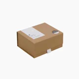 Brown cardboard gift box with white label and round sticker.