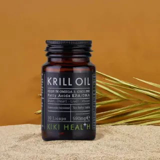 Krill Oil supplement bottle on sand with grass, labelled high in Omega 3, choline, 590mg, 30 Licaps.