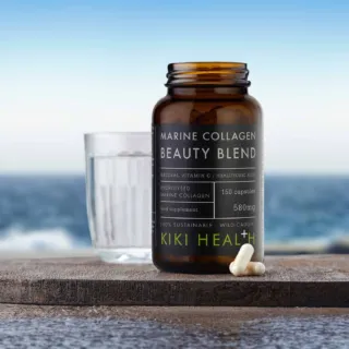 Marine Collagen Beauty Blend bottle with capsules, glass of water, ocean background.