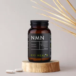 NMN supplement bottle with 60 vegetarian capsules, 500mg, on a wooden stand.