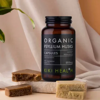 Kiki Health Organic Psyllium Husks capsules, 850mg, with soap bars on a fabric background.