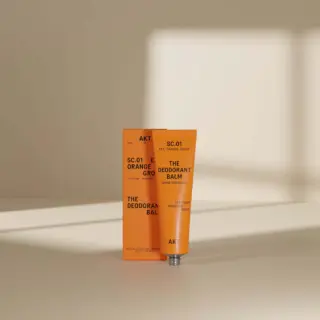 Orange deodorant balm tube and box with text "SC.01 EXT. ORANGE GROVE".