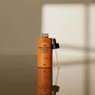 Orange bottle of body oil with dropper, labelled "The Everyday Encore Body Oil".