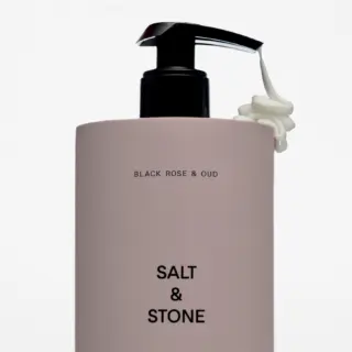 Salt & Stone bottle with pump, text: Black Rose & Oud. Cream dispensed from nozzle.