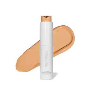 White bottle of RMS Beauty foundation with beige swatch behind.
