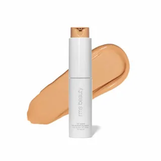 White bottle of RMS Beauty foundation with beige swatch behind.