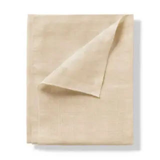 Beige linen cloth folded with a corner turned up.
