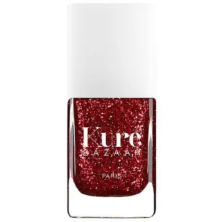 Kure Bazaar red glitter nail polish bottle with white cap.