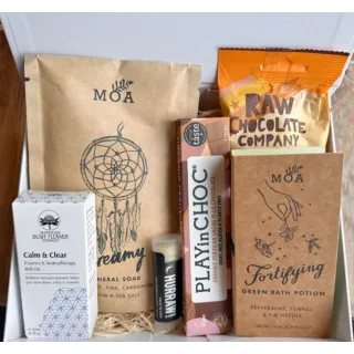 Wellness gift box with MOA bath products, chocolate, lip balm, and aromatherapy roll-on.
