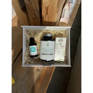 Cleansing products in a white box on a wooden surface, including CytoCleanse Formula and Cleavers Tincture.
