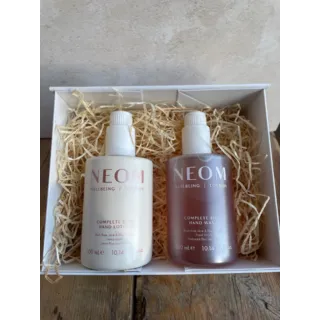 Neom hand lotion and wash set in a white box with straw filling.