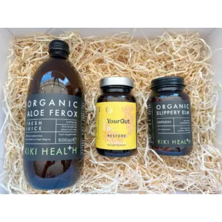 Three Kiki Health supplements on straw: Aloe Ferox juice, YourGut Restore, Slippery Elm capsules.