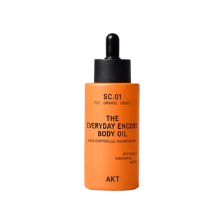 Orange bottle of AKT Everyday Encore Body Oil with dropper lid.