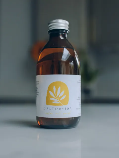 Brown bottle with Castorvida label on a white surface.